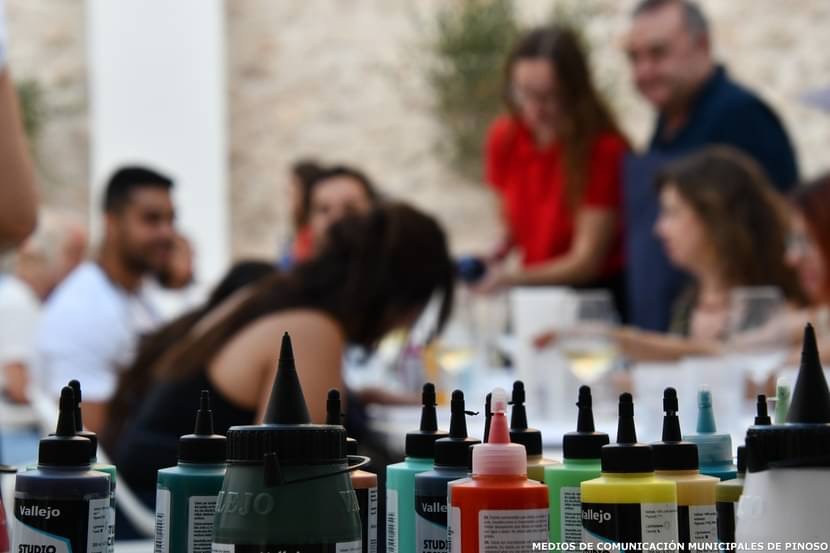 Botes de pintura en primer plano durante el desarrollo del taller Arte y Vino